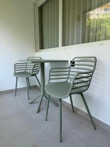 three chairs and a table in front of a building at Luxor Suites Olimpou in Thessaloniki
