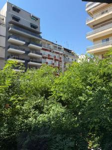 a tall apartment building with trees in front of it at Luxor Suites Olimpou in Thessaloniki