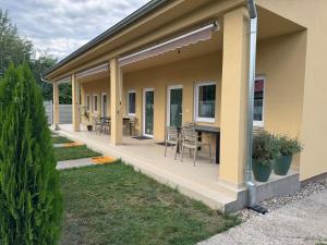 a house with a porch with chairs and a table at Primera Apartments in Palić