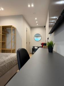 an office with a table and a bed in a room at Luxor Suites Olimpou in Thessaloniki