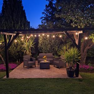 a patio with chairs and a pergola with lights at Guesthouse Dida in Sapareva Banya