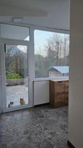a cat is looking out the window of a house at Apartment 42 in Ljubuški