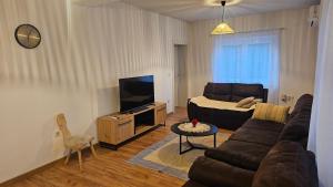 a living room with a couch and a tv at Apartment 42 in Ljubuški
