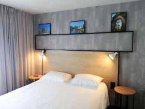 a bedroom with a large white bed with two tables at ibis Poitiers Sud in Poitiers +63 photos