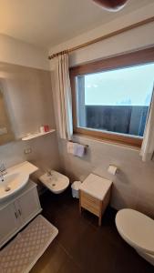 ein Badezimmer mit zwei Waschbecken und einem Fenster in der Unterkunft Ciasa Saina in Wengen + 16 Fotos