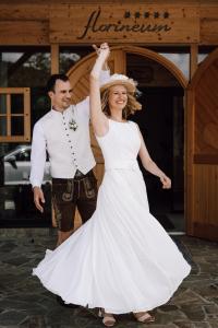 a bride and groom are dancing in front of a building at Florineum in Weyregg
