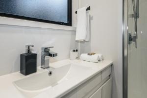 a white bathroom with a sink and a window at Alpine Chalets in National Park +15 photos