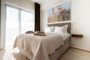 a bedroom with a large bed with towels on it at Marienholm Seaview Apartment in Haapsalu