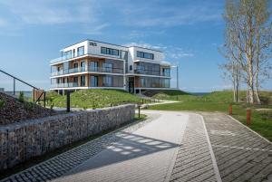 a house on top of a hill with a walkway at Marienholm Seaview Apartment in Haapsalu