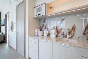 a kitchen with white cabinets and a sink at Marienholm Seaview Apartment in Haapsalu