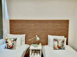 two beds sitting next to each other in a room at The Stetson - Paarl - Self Catering Apartment in Paarl