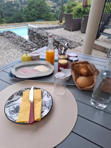 a table with plates of food and a basket of bread at La parenthèse in Puy-dʼArnac