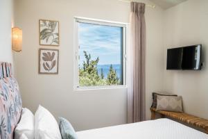 a bedroom with a bed and a window at Villas Muscalas by Konnect, 200m from the Beach in Lákka +47 photos