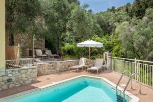 a swimming pool with an umbrella and chairs and a patio at Villas Muscalas by Konnect, 200m from the Beach in Lákka