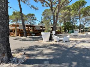 a building with white chairs and trees in a park at Soucado in Fréjus