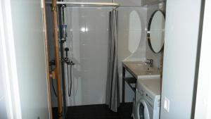 a bathroom with a shower and a washing machine at Lomaniini in Tahkovuori