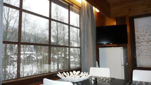 a dining room with a table and a large window at Lomaniini in Tahkovuori