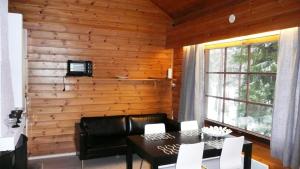 a living room with a table and chairs and a wooden wall at Lomaniini in Tahkovuori
