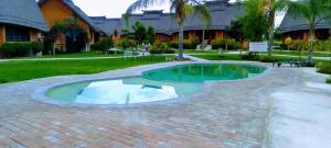 a swimming pool in the middle of a brick patio at Ekori Lodge in Mamuno