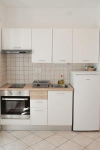 a kitchen with white appliances and white cabinets at Accordi Lontani in Nerezine