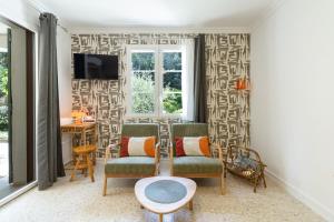 a living room with two chairs and a table at Beau studio dans mas provençal in Avignon