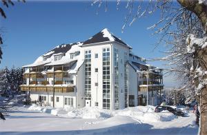 a large white building with snow around it at Hotel Zum Bären in Kurort Altenberg