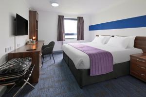 a hotel room with a large bed and a desk at Fire Service College in Moreton in Marsh +11 photos