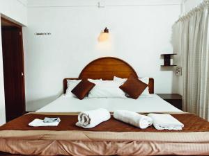 a bedroom with a bed with towels on it at Ambadi's villa -Lake view resort in Pallipuram +145 photos
