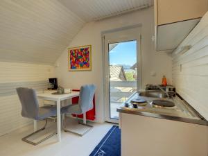 a kitchen with a desk and a table with chairs at Apartments Dolžan in Bled