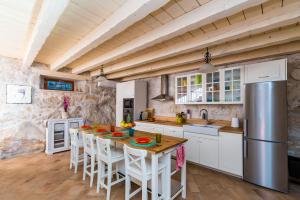a kitchen with a table with chairs and a refrigerator at Villa Dalmata in Brsečine