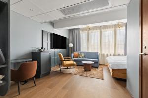 a hotel room with a bed and a couch at Best Western Plus Savoy Lulea in Luleå
