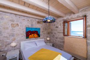 a bedroom with a bed in a stone wall at Villa Dalmata in Brsečine