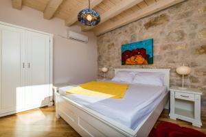 a bedroom with a bed and a painting on the wall at Villa Dalmata in Brsečine +52 photos