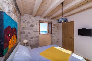 a bedroom with a bed and a painting on the wall at Villa Dalmata in Brsečine