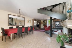 a dining room with a red table and chairs at Le Logis des Douves in Tiffauges