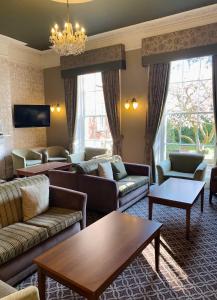 a living room with couches and tables and a chandelier at Lysses House Hotel in Fareham