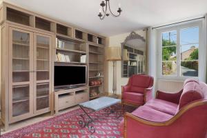 a living room with two chairs and a television at Le Logis des Douves in Tiffauges
