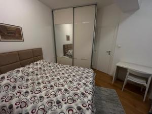 a bedroom with a bed and a table and a mirror at Skyline Residence Podgorica in Podgorica