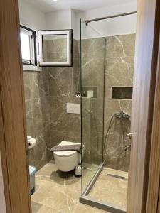 a bathroom with a toilet and a glass shower at Gardenia studios in Nydri +34 photos