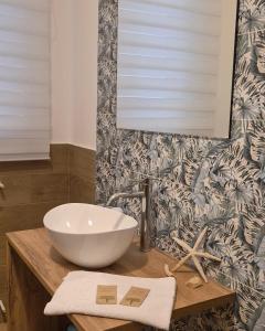 a bathroom with a white bowl sink on a counter at Maresia Apartment in Altavilla Milicia +28 photos