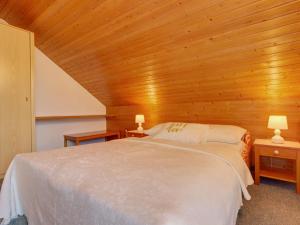 a bedroom with a white bed in a wooden ceiling at Apartments Dolžan in Bled