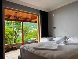 a bedroom with a large bed with a large window at Sarp Bungalov in Kemalpasa