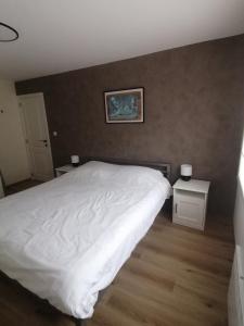 a bedroom with a white bed and two night stands at Marisol in Bredene
