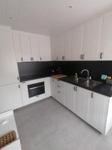 an empty kitchen with white cabinets and a sink at Marisol in Bredene