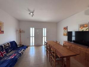 a living room with a table and a couch and a tv at Casa en Riumar in Riumar