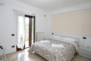 a white bedroom with a bed and a window at Introdacqua Holidays in Sulmona +33 photos