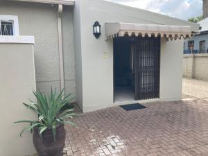 a house with a door and a potted plant at 51 on Parfitt in Bloemfontein
