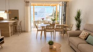 a kitchen and living room with a table and chairs at Hermosa casa con piscina cerca de la playa de Punta Prima in Punta Prima