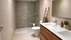 a bathroom with a toilet and a sink and a shower at Hermosa casa con piscina cerca de la playa de Punta Prima in Punta Prima +11 photos