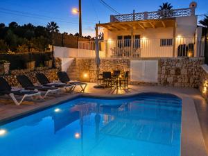 a swimming pool in front of a villa at night at Hermosa casa con piscina cerca de la playa de Punta Prima in Punta Prima
